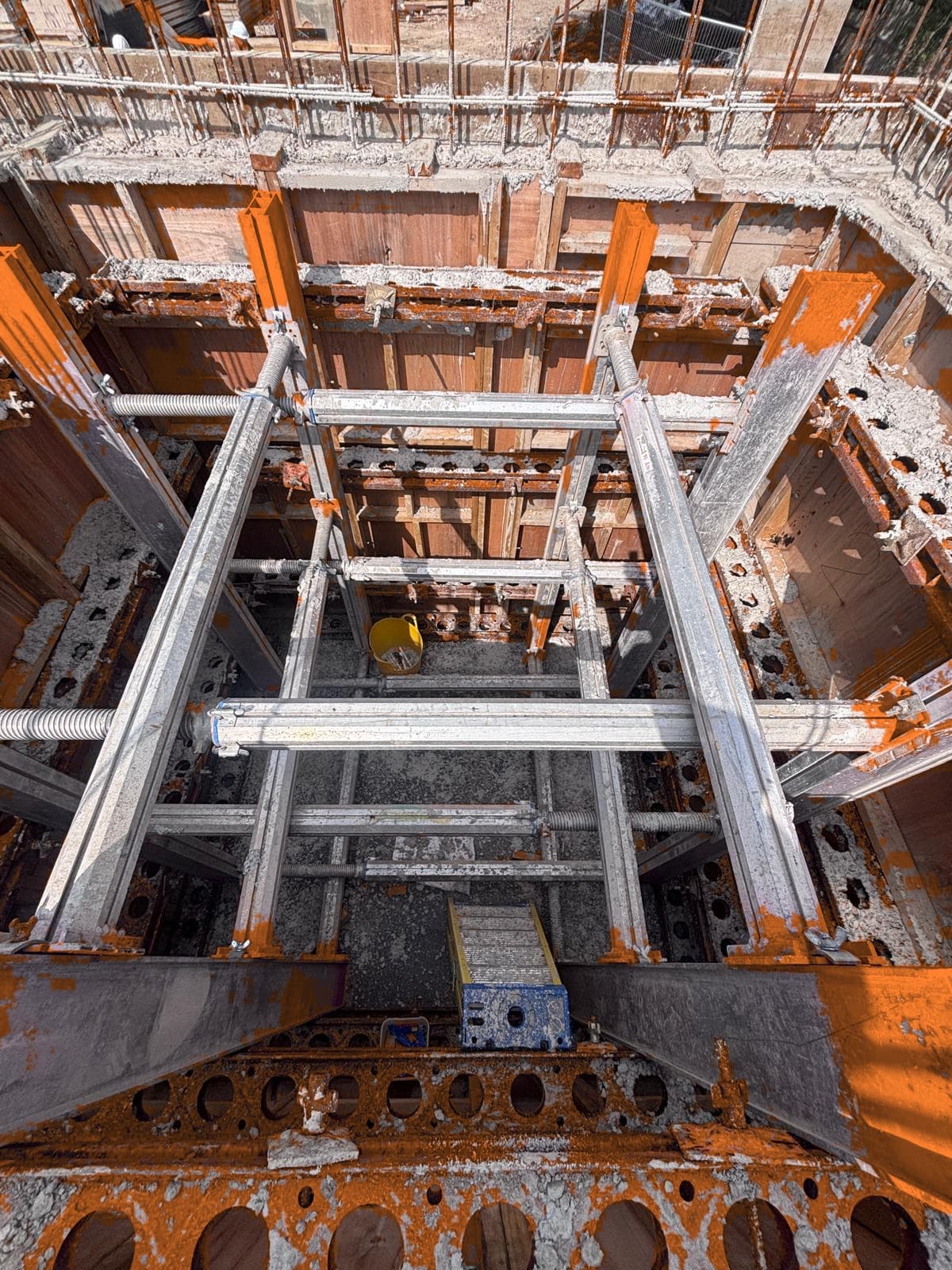 Top-down view into deep RC lift shaft with internal formwork shuttering