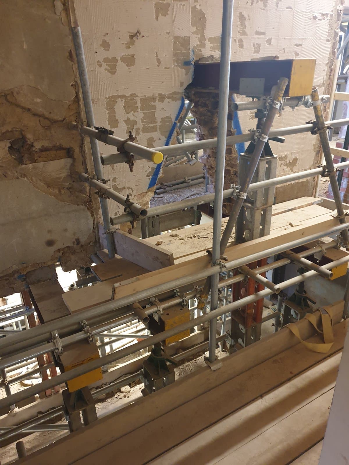 Needle beams passing through a masonry wall with props beneath during the hotel refurbishment