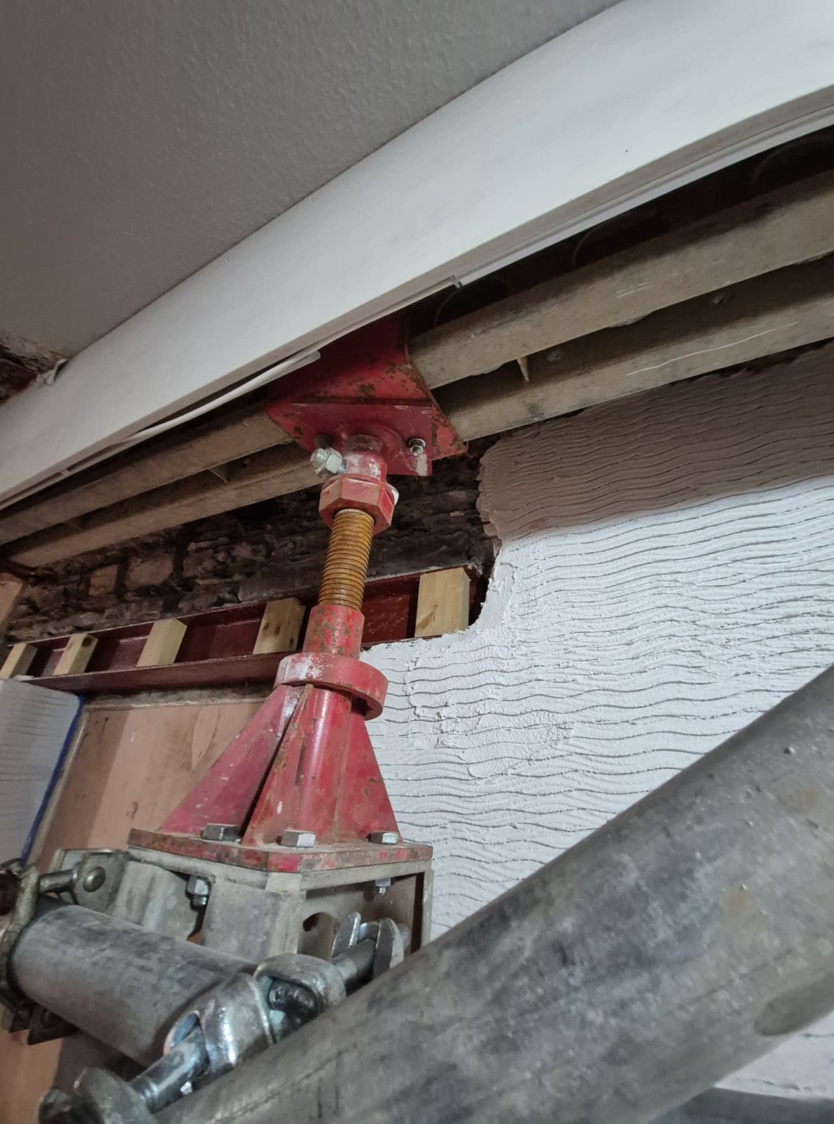 Slimshore adjustable base at the prop head packed with timber beneath an existing steel beam