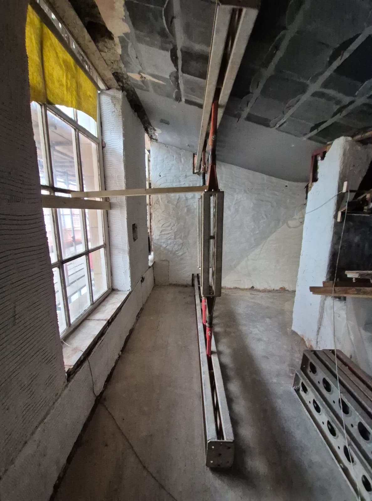 Slimshore prop with left and right hand jacks between header and spreader beams beneath the filler joist floor