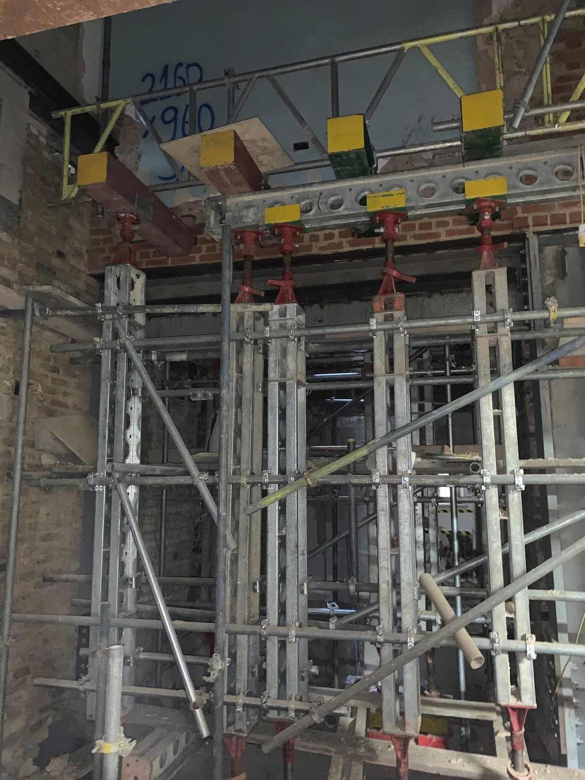 Slimshore soldier towers standing beneath needle beams through the wall