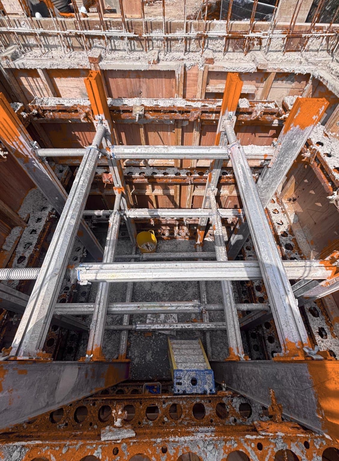 Top-down view into deep RC lift shaft with internal formwork shuttering