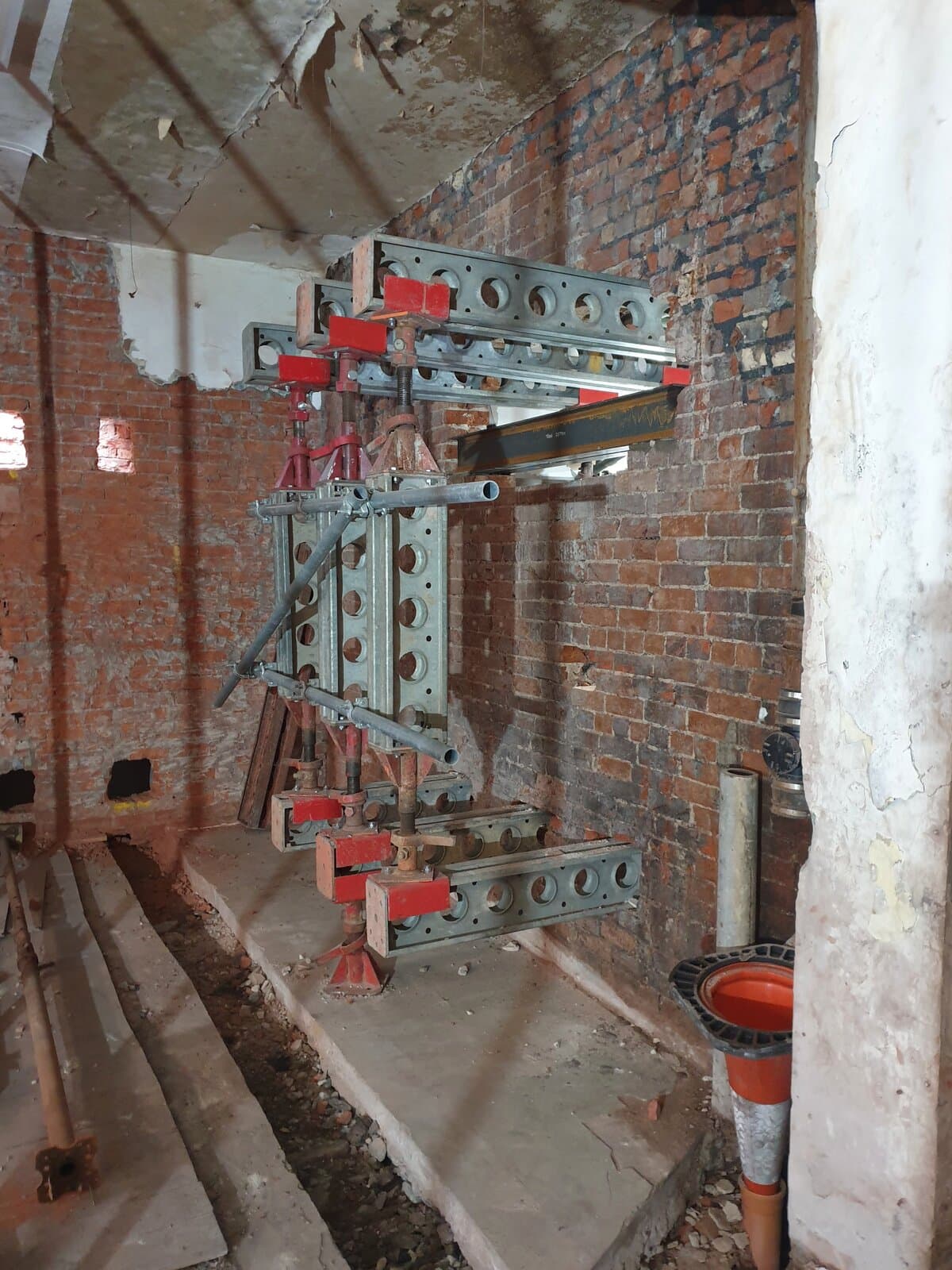 Slimshore needle beams through a brick wall, carried on Slimshore props down to spreader beams on the slab